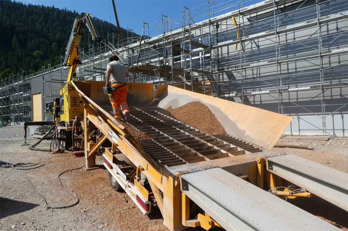 Alte zermahlte Ziegeln, gemischt mit Kompost, werden aufs Flachdach gepumpt.