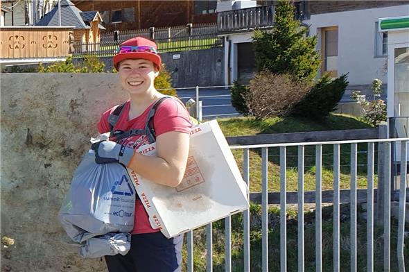 Anja Ginggen mit vollem Abfallsack und leerer Pizzaschachtel.