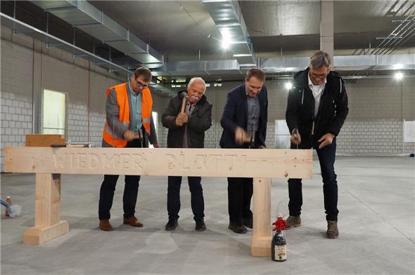 Aufrichtefeier in der Migros Zweisimmen: Damit die Handwerker etwas zum Lachen haben, müssen die Theoretiker Nägel einschlagen: Norbert Scholz, Gesamtprojektleiter Bau; Ernst Hodel, Gemeinderatspräsident von Zweisimmen; Heinz Rüedi, Leiter Entwicklung, Bau und Betrieb sowie Architekt Heinz Brügger.