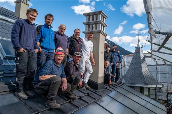 Aufrichtefest mit den Baufachleuten: die Handwerker mit Ursula Zybach (rechts neben dem Schornstein) und die neue thermische Solaranlage, im Hintergrund das restaurierte polygonale Erkertürmchen.
