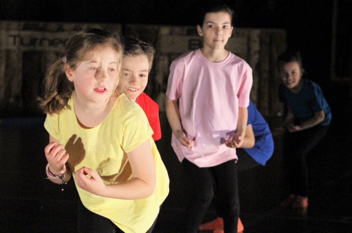Ausdrucksstarke Buben- und Mädchen-Gruppe beim sportlichen Tanz.