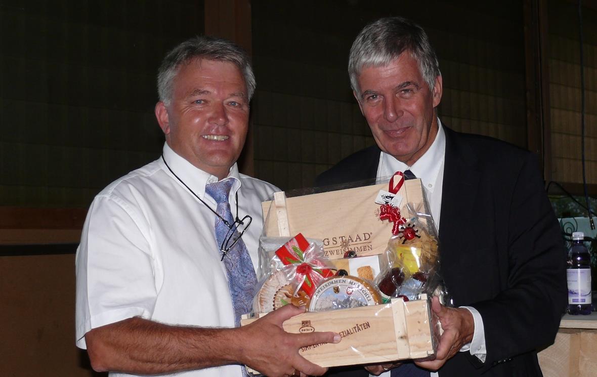 Bankleiter Werner Ziörjen überreicht dem Referent Dr.Christoph Koellreuter ein Geschenk-Kistli.