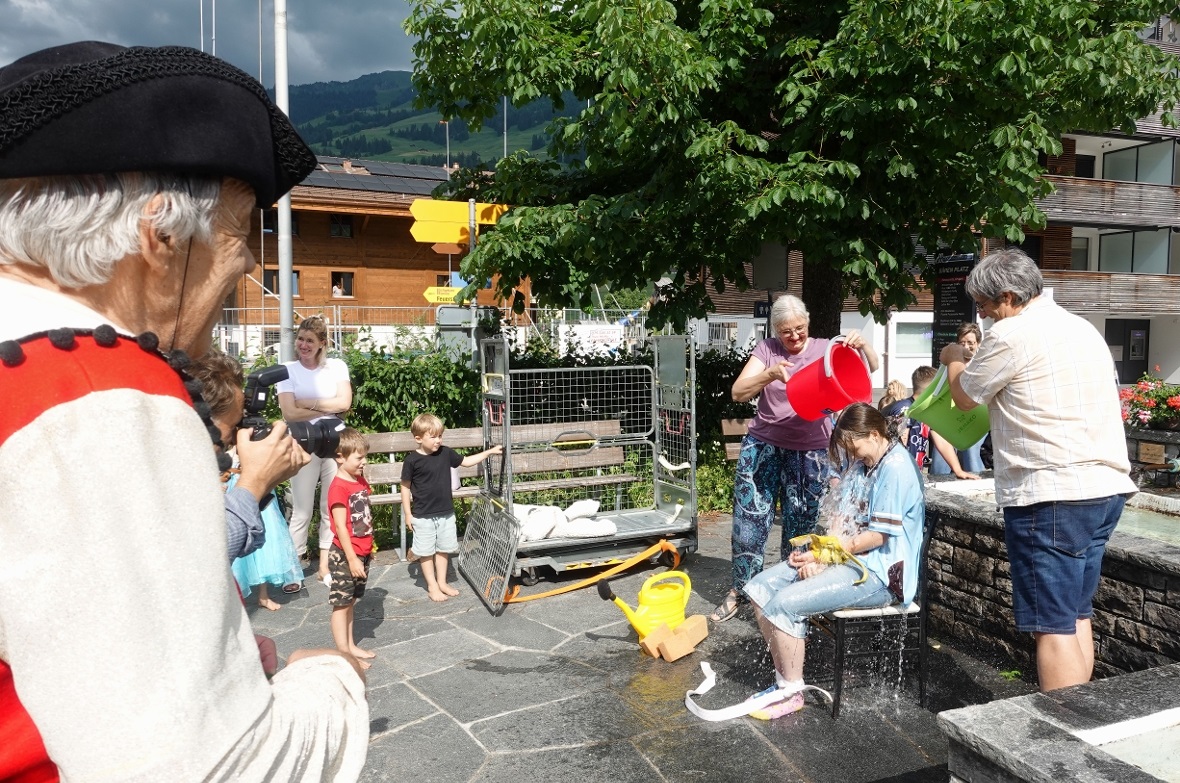 Beim Absitzen auf den nassen Schwamm wehrte Noemi sich vergeblich … und «der durst’gen Seel ein Sturzbad obendrauf»: Chefsleute und Ausbilder Kerstin und Fabian Kopp vollziehen die traditionelle Wassertaufe.