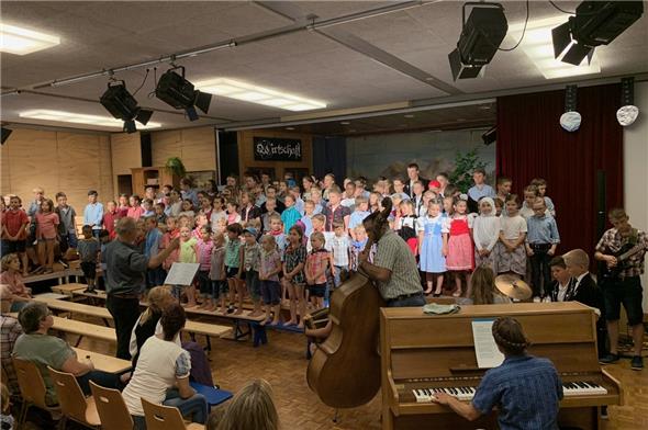 Beim Gesang des Gesamtliedes «Hie bin i dehei» von George mit musikalischer Unterstützung durch das Schülerorchester, verstärkt mit den Eltern Zurbuchen, schwoll die Stimmung im Saal an.