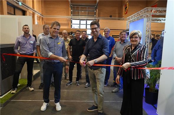 Berner KMU-Direktor Lars Guggisberg durchschnitt das rote Band, flankiert von OK-Präsident Tom Wittwer und Vizepräsidentin Manuela Radon.