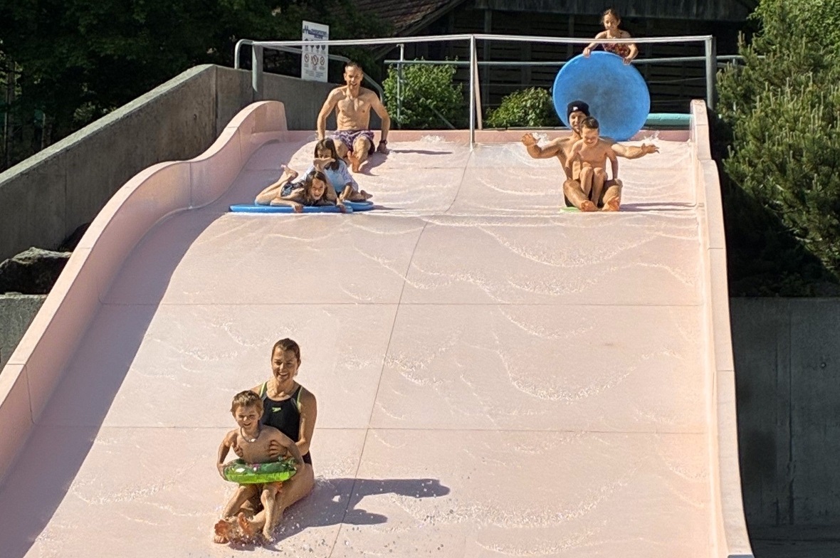Brrr… Salome und Ramona sind die Ersten im 15°-Wasser. Auf der Rutschbahn sind Liana und Anais auf dem Brett, Marco, Angela mit Livio (vorne), Melina mit Brett, Andreas mit Franjo-Hube und Lukas. Alle sind Sieger, Bravo!