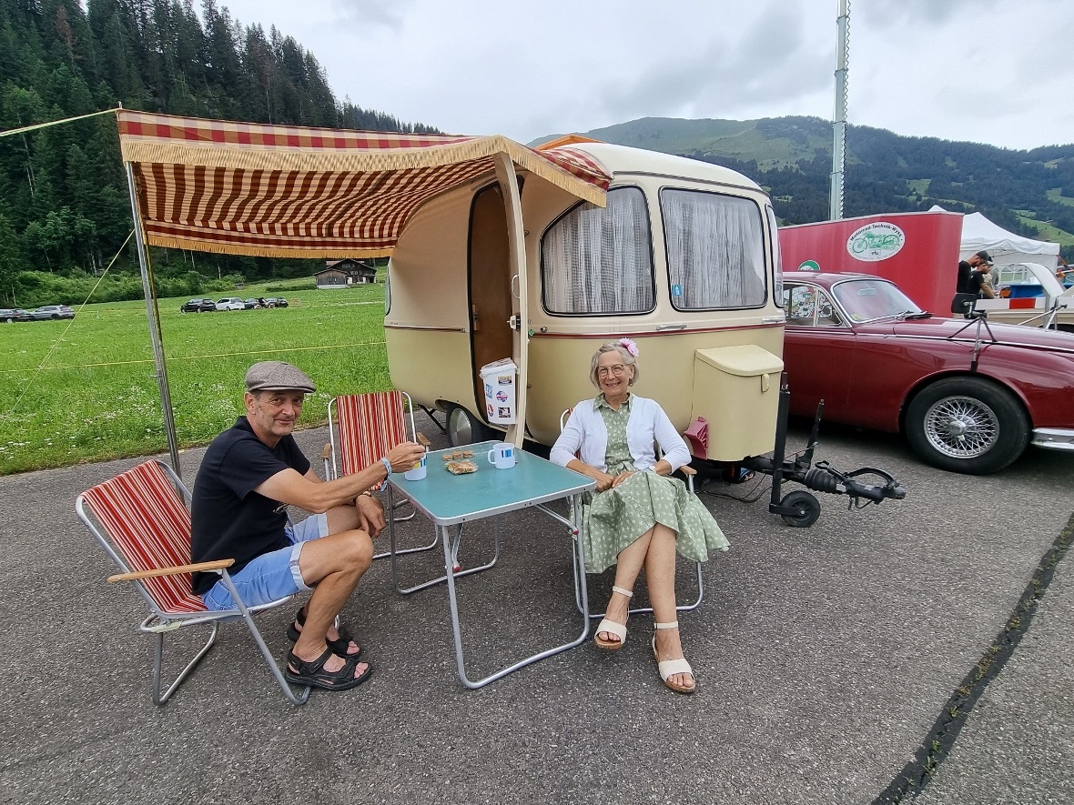 Christina und Thomas vor dem Wohnwagen aus Polyester, im Hintergrund der Jaguar.