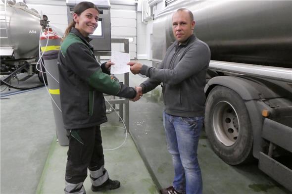 Daniel Wochner, Bereichsleiter Käseproduktion, nimmt den ersten Milch-Lieferschein von Jolanda Beck, Fahrerin der Rolli Transporte AG, entgegen.