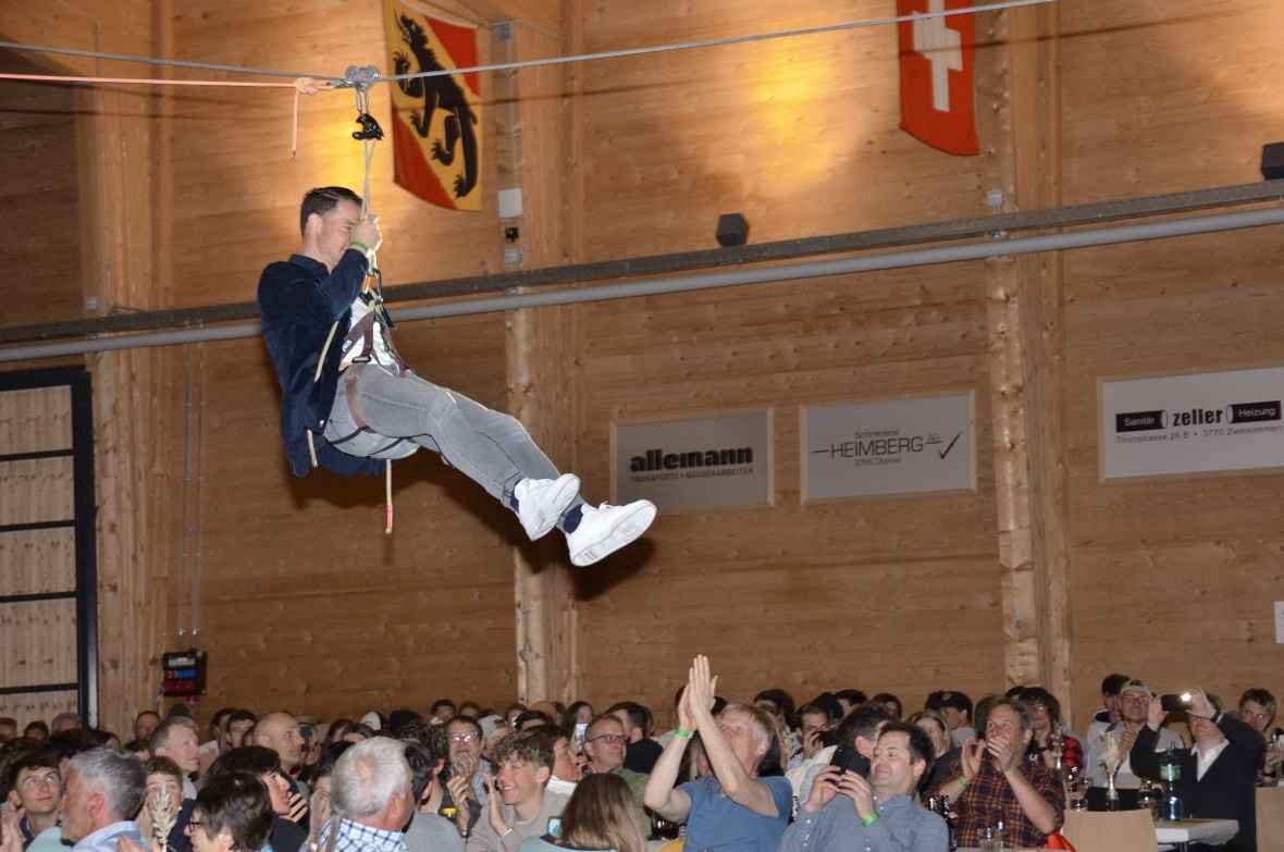 Dario Cologna glitt an der Zipline quer über das jubelnde Publikum in der Simmen...