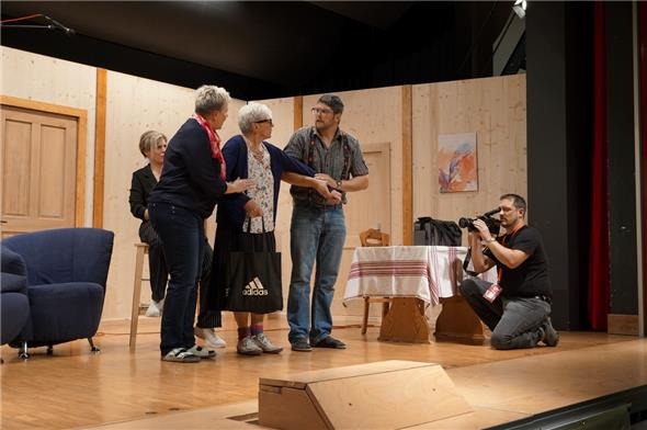 Das echte Grosi ist nicht aus dem Haus zu bringen, auch sie will an der Fernsehsendung teilnehmen: Birgit, Grosi, Wolfgang, der Kameramann und im Hintergrund die Reporterin.