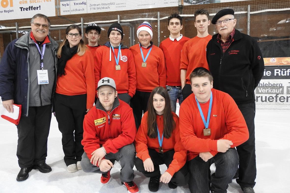 Das erfolgreiche Schweizer Team posiert mit den Bronzemedaillen, flankiert von U...