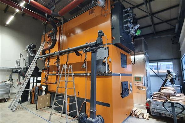 Der 2400-kWh-Holzschnitzel-Feuerungsofen konnte diesen Sommer ebenerdig in die bestehende Lastwagen-Garage der ehemaligen Mühlemann Transport AG aufgebaut und installiert werden (Foto kurz vor Inbetriebnahme).