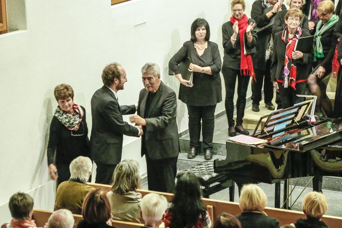 Der Dirigent Beat Spörri übergibt an Chasper-Curò Mani.