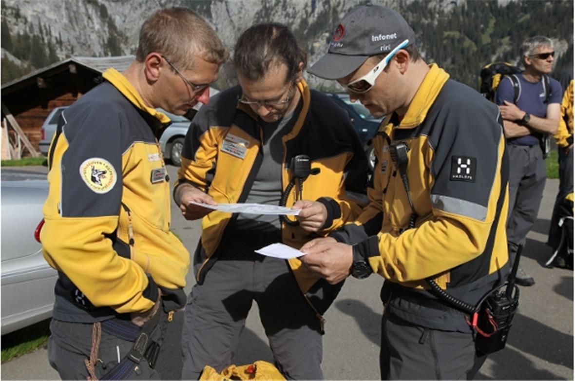 Der Einsatzleiter mit dem Hundeführer und einem Gruppenchef bei der Besprechung vor dem Start.