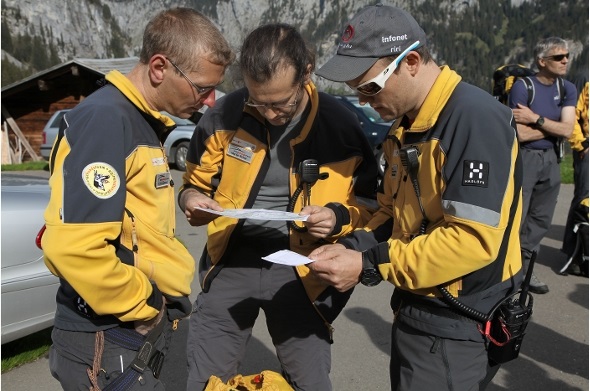 Der Einsatzleiter mit dem Hundeführer und einem Gruppenchef bei der Besprechung vor dem Start.