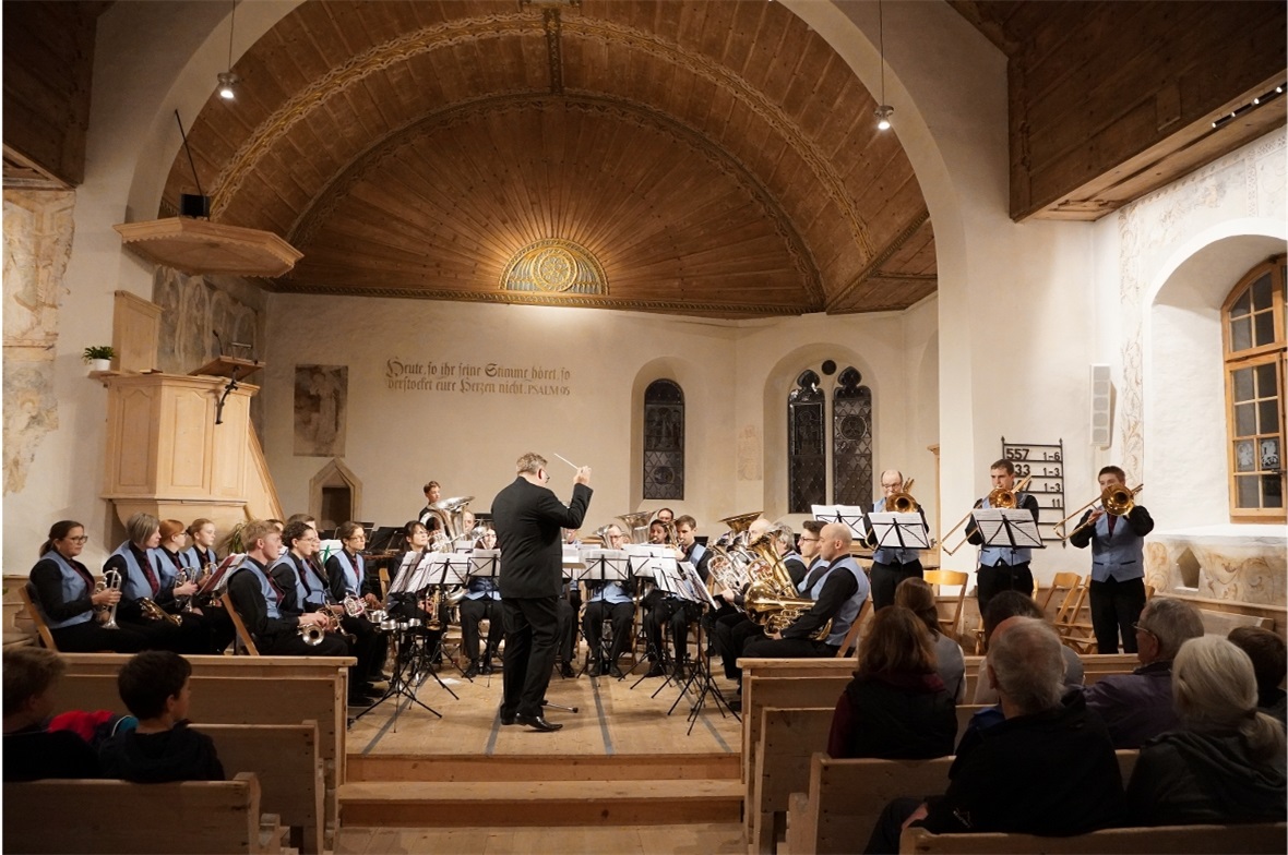 Die Brass Band Harmonie Saanen unter der Leitung von Michael Bach, rechts das Po...
