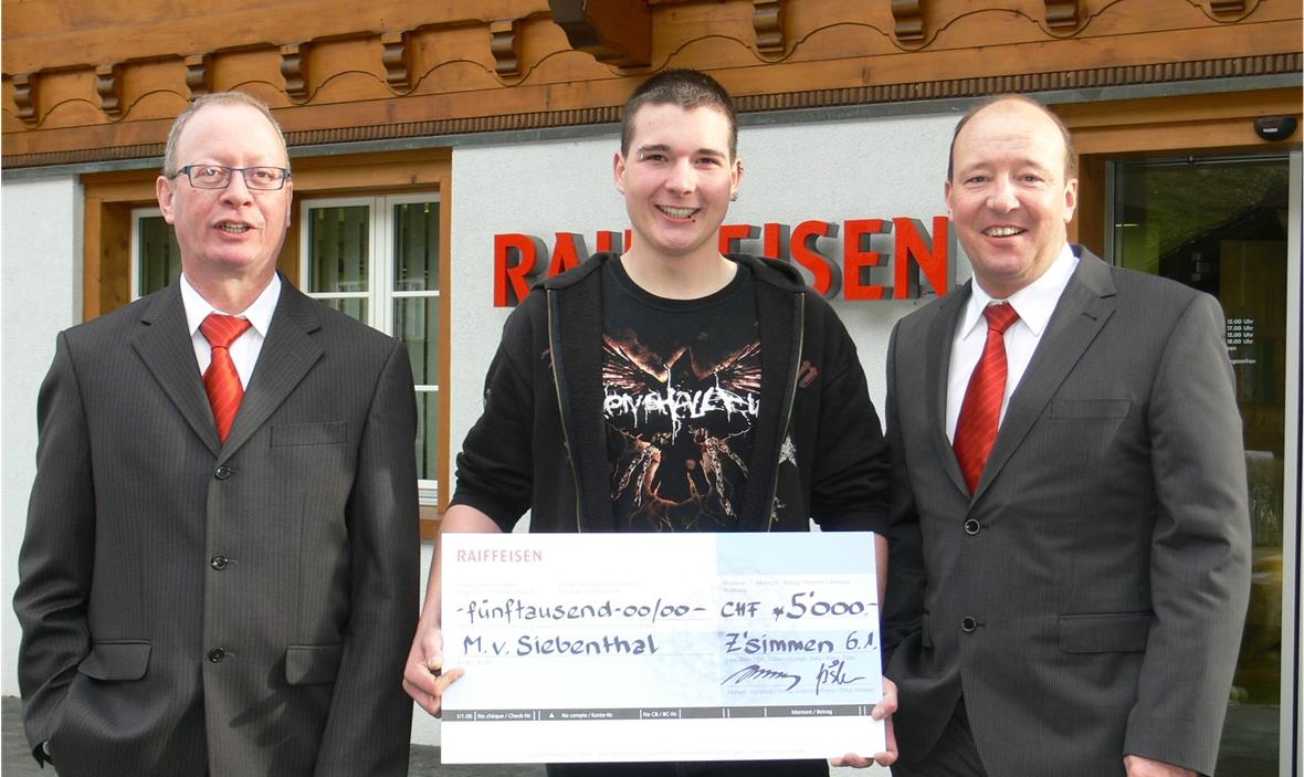 Michael, ein Glückspilz am Dreikönigstag Die Checkübergabe bei der Raiffeisen Filiale in Reidenbach. Glückspilz Michael von Siebenthal zwischen Hans Amport, Leiter der Bankfiliale (links) und Bankleiter Toni Matti (rechts).