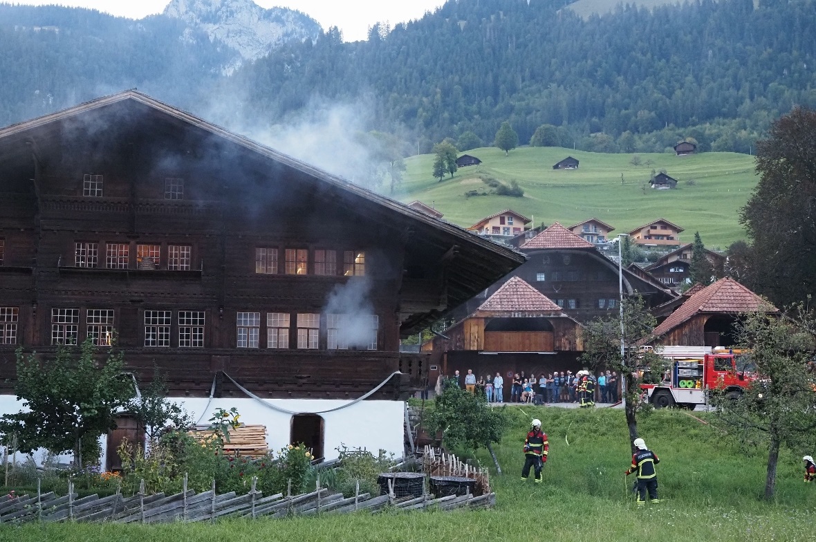 Die Feuerwehr Erlenbach beim «Löschen des Brandes» im Agensteinhaus. Im Hintergrund sind die Zuschauer zu sehen, die die kommentierte Übung mitverfolgen.