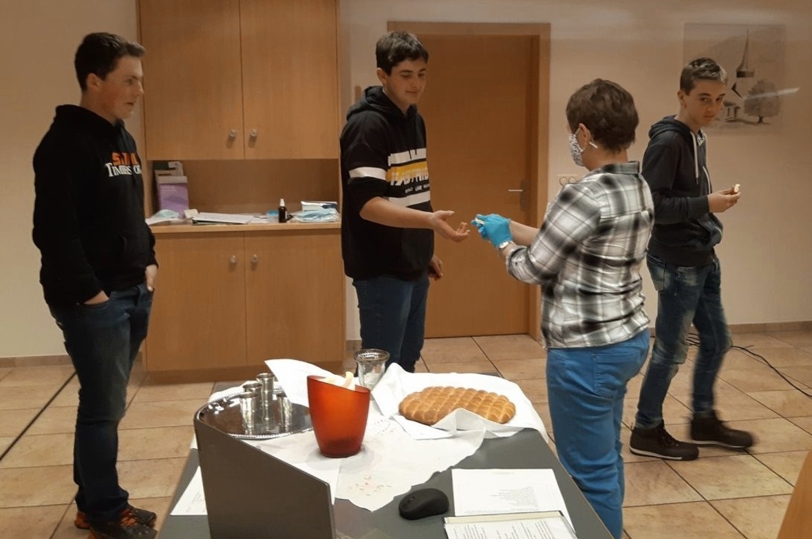 Die Jugendlichen erhalten das Abendmahl im Kirchgemeinderaum.