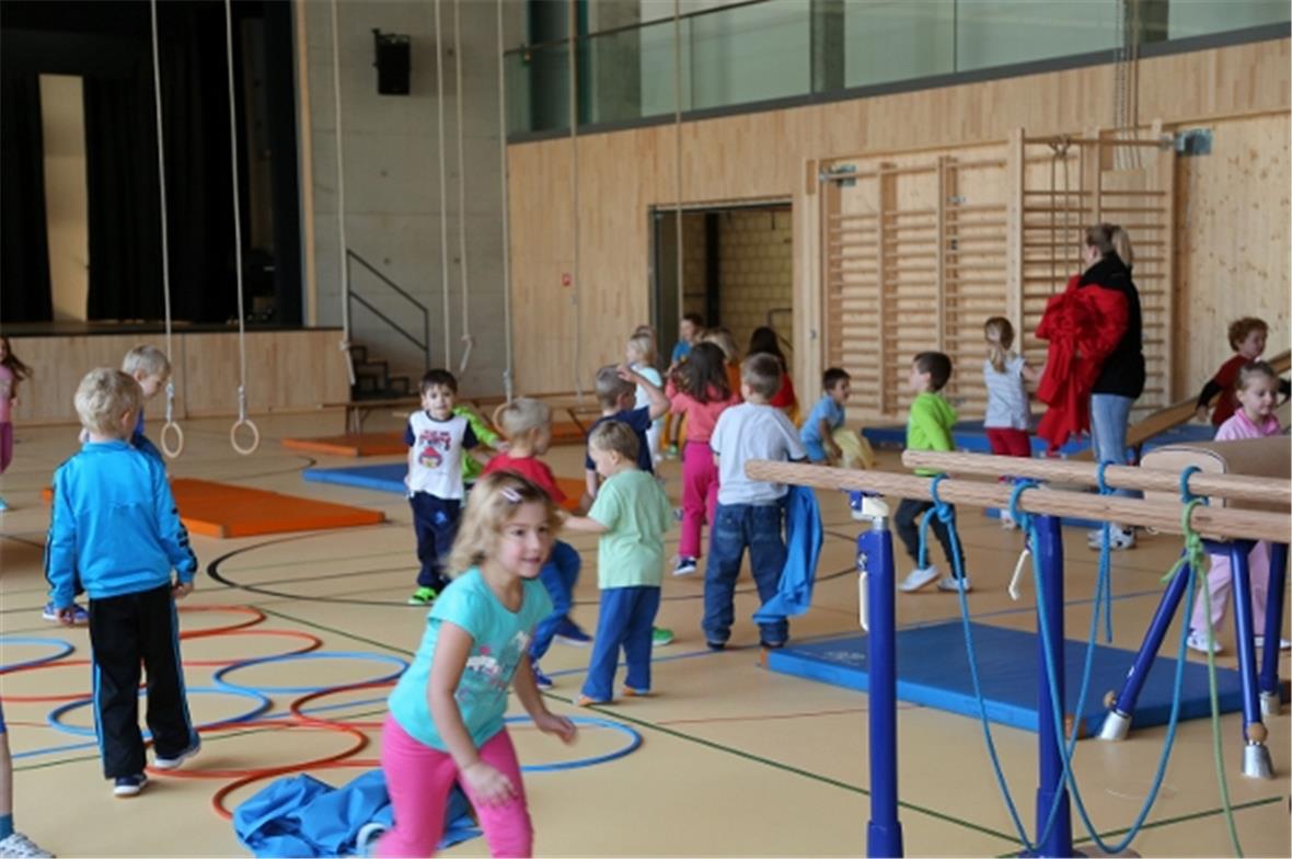 Die Kinder besetzen die neue Turn- und Sportanlage.