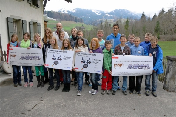 Die Oberwiler Schulklasse mit ihrem Siegerplakat und den beiden Gutscheinen. Im Hintergrund ihre Lehrerein Sandra Hählen mit Ehemann.