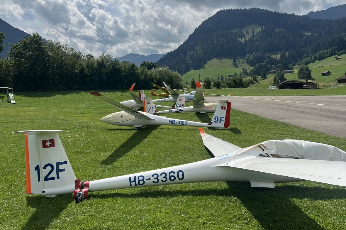 Die Segelflugzeuge am Morgen vor dem Start. Die Wolken im Hintergrund zeigen, dass die Thermik schon bereit ist für schöne Flüge.