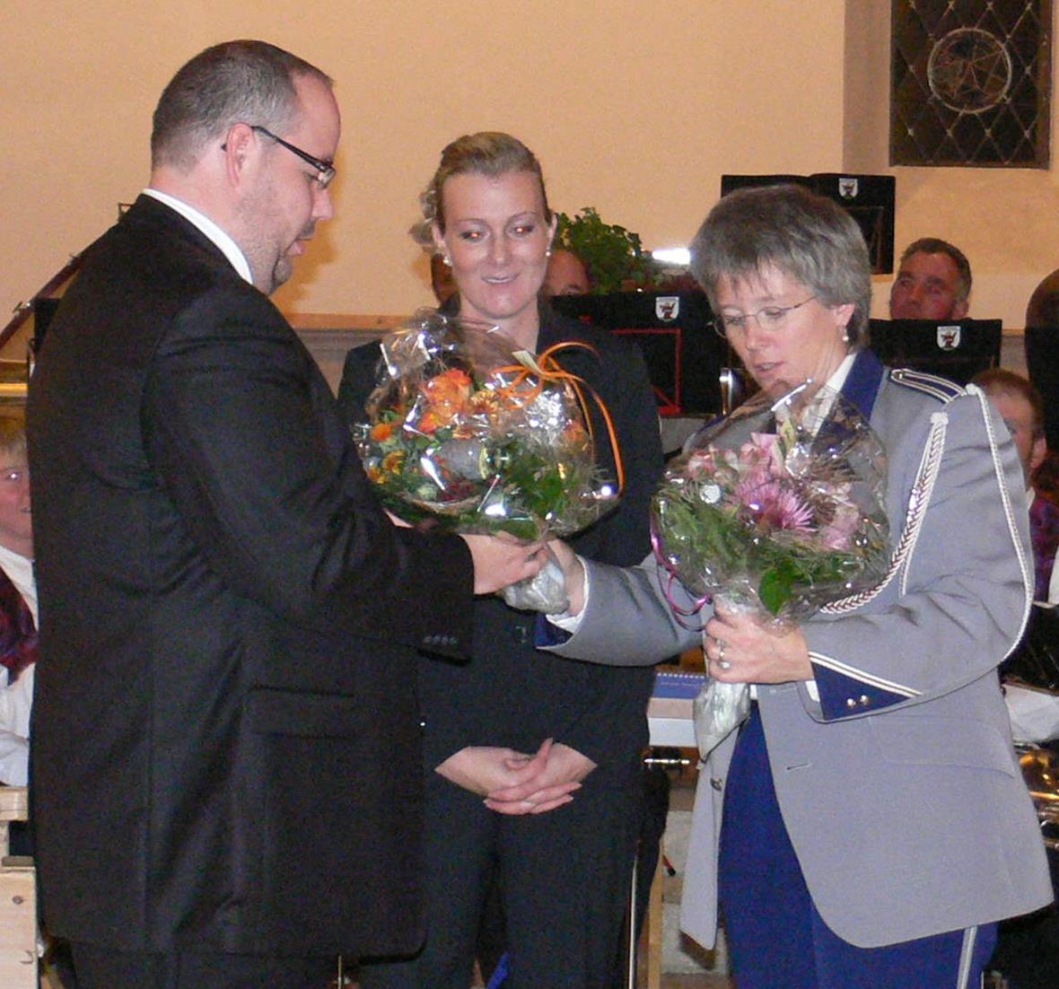 Musikanten aus St. Stephan zu Gast Die beiden Dirigenten Hanspeter Janzi (l.) und Karin Moor (m.) haben sich die Blumen verdient. Die Sträusse wurden von Beatrice Zeller (r.), Zweisimmer Musikpräsidentin, überreicht.