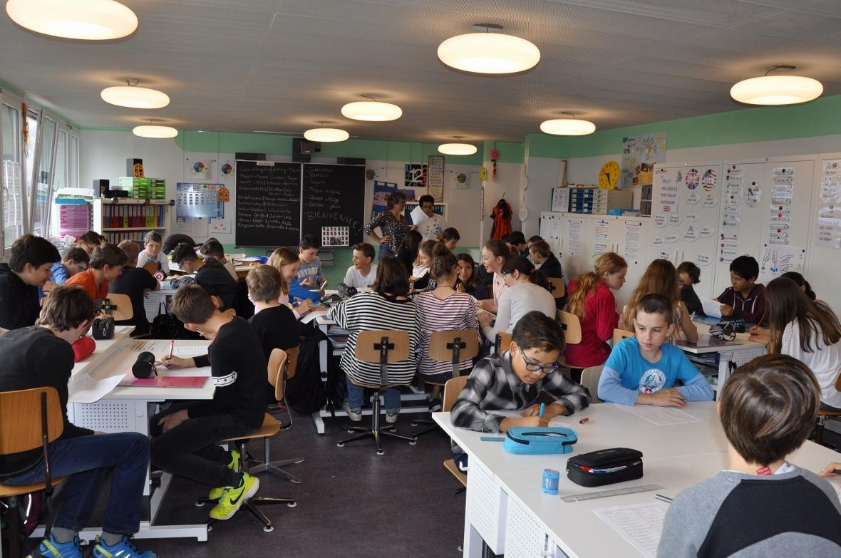 Die beiden Patenklassen im Klassenzimmer der Klasse aus Vouvry beim Lösen des Qu...