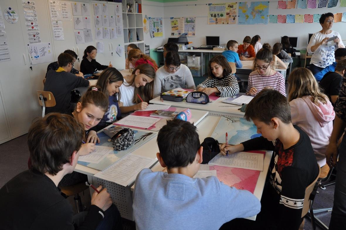 Die beiden Patenklassen im Klassenzimmer der Klasse aus Vouvry beim Lösen des Qu...