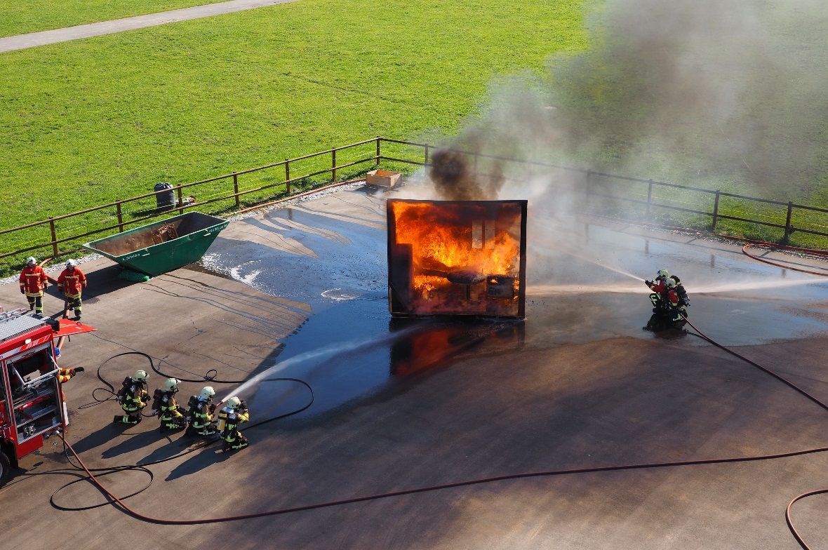 Die eintreffenden Feuerwehrleute bergen die bewusstlose Person und beginnen sofo...