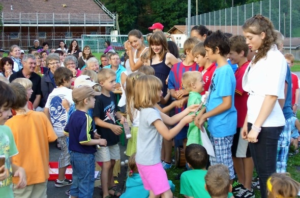 Die künftigen Erstklässler übergeben den austretenden 6. Klässlern ein Geschenk mit auf den Weg ins OSZ Zweisimmen.