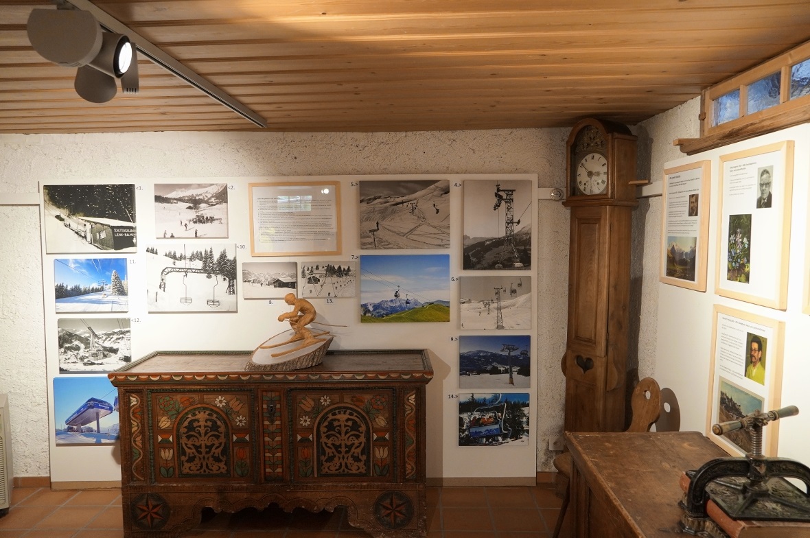 Die Faszination der Vergangenheit Ein Blick in die Ausstellung mit der Fotowand zur Entwicklung der Bergbahnen und dem hölzernen Skifahrer von Pascal Baur.