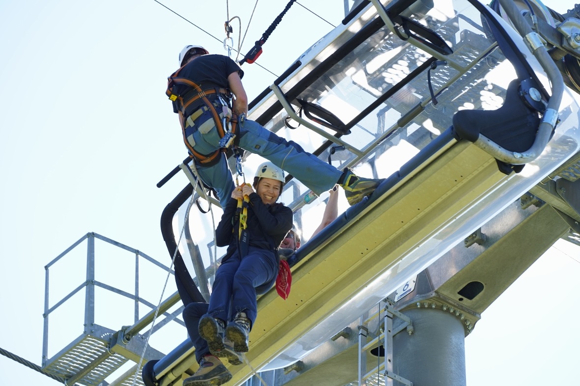 Eine Figurantin wird sicher aus dem Sessel zum Boden gelassen.
