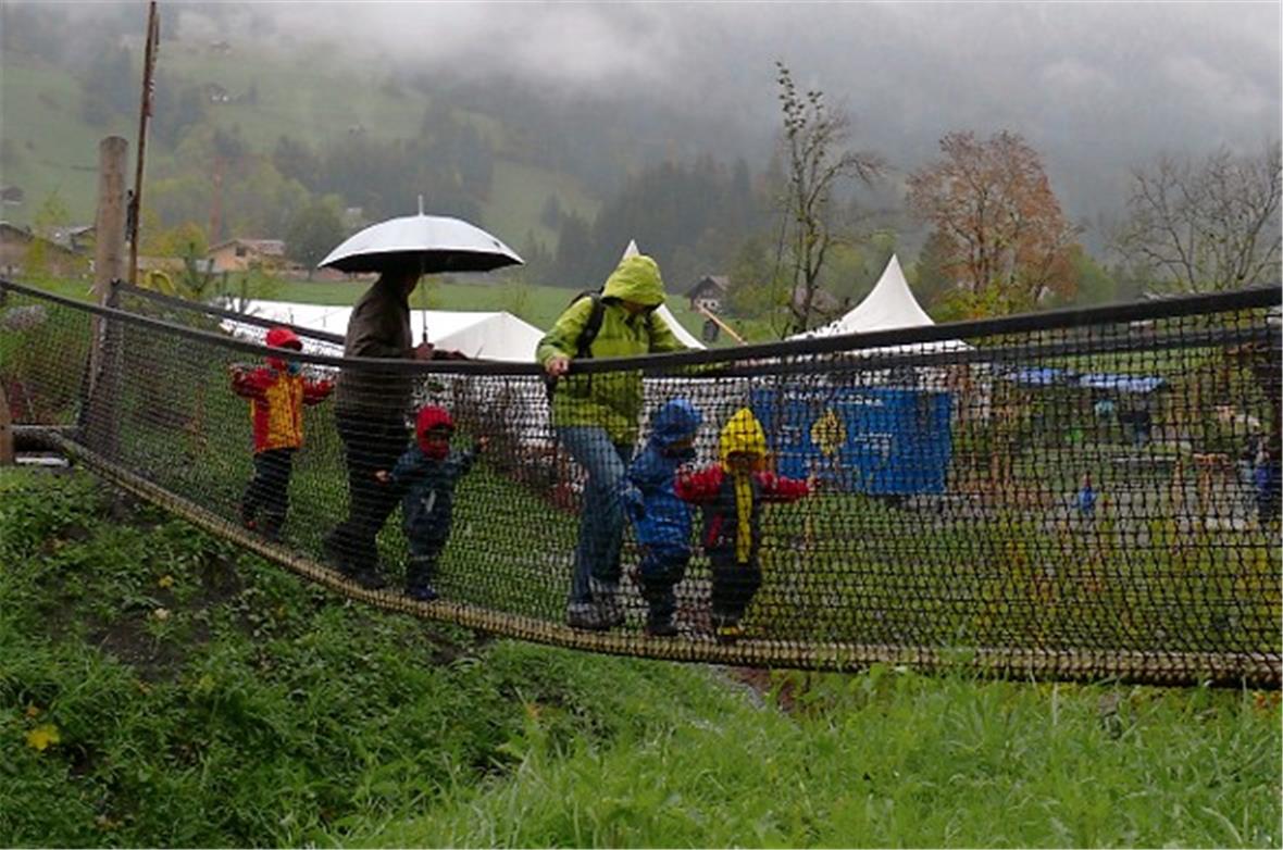 Eine lange Seilhängebrücke verbindet zwei Wälle spielerisch miteinander.