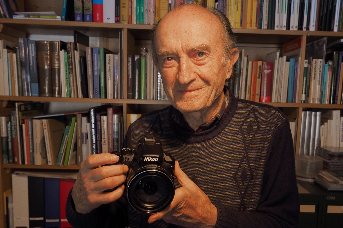 Ernst Zbären in seinem Arbeitszimmer mit seiner Digital-Kamera, die den unglaublichen Zoom-Bereich von 24–2000 Millimeter abdeckt.