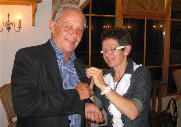 Esther Hählen steckt Werner Haari die Präsidentennadel ans Revers.