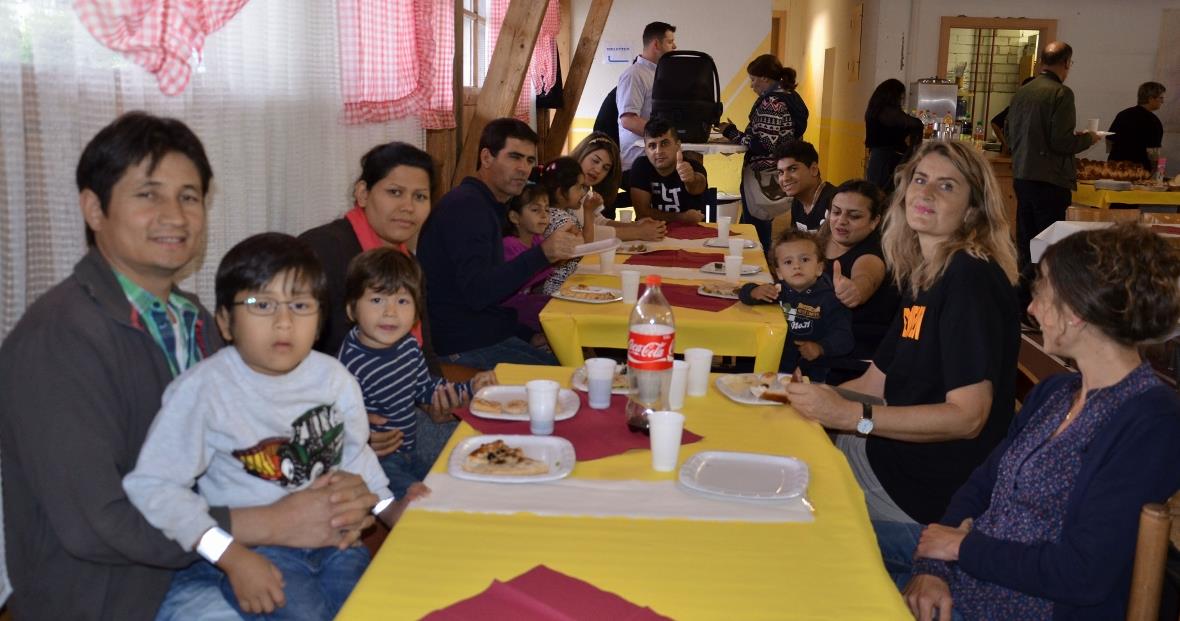 Flüchtlingsfamilien, Betreuer und Gäste tafelten gemeinsam und freuten sich am gelungenen Zusammentreffen. Die Familie mit ihren zwei Knaben (links) kommt aus Afghanistan und ist von Beginn weg in Zweisimmen.