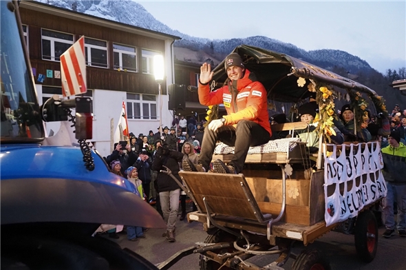 Franjo von Allmen wird auf auf einem geschmückten Wagen und den Kindern der JO Boltigen auf den Festplatz gefahren.