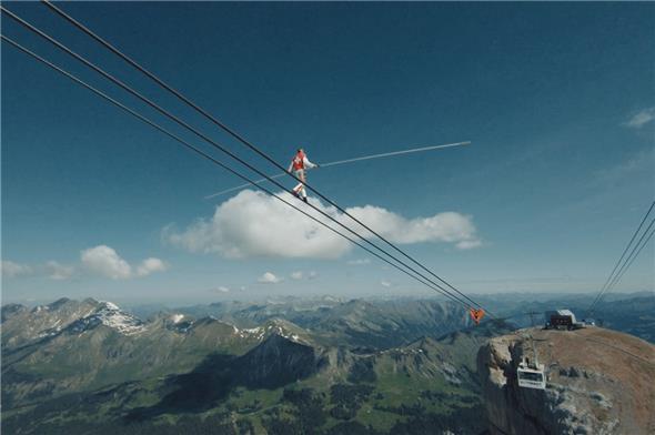 Freddy Nock legt 40 Meter auf dem steilsten Abschnitt der Seilbahn Col du Pillon–Cabane zurück, wobei er auf dem Tragseil der Seilbahn geht, in seinem bevorzugten Stil, ohne zu sichern, nur mit seinem Balancierstab.