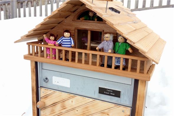 Fröhlich grüsst die kleine Familie oberhalb des Briefkastens von Familie Krauer-Meier.