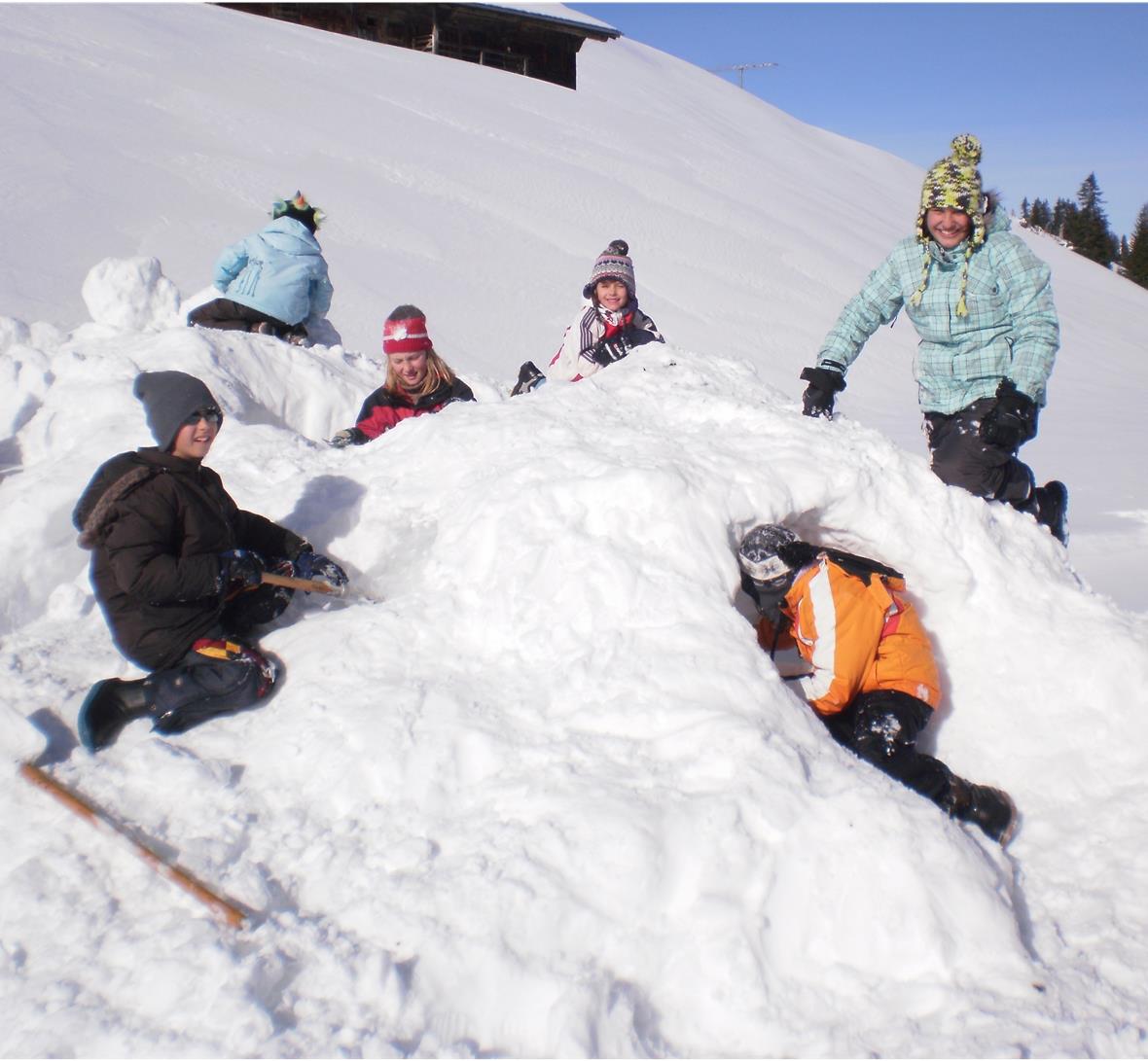 Gross und klein in Aktion beim Schneeskulpturen bauen (Sparenmoos).