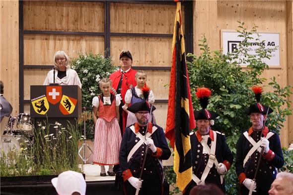 Grossratspräsidentin Anne Speiser mit ihren beiden Grosstöchtern Joëlle (8) und Zoé (11) bei ihrer Ansprache, begleitet vom Staatsweibel und der Ehrenformation.