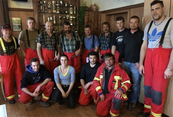 Gruppenfoto mit abtretenden und neuen Feuerwehrmitgliedern in der Mitte, Ueli Stocker (links aussen stehend), Andy Gafner und Reto Maurer (rechts aussen stehend) und dem neuen Kommandanten Dominik Blatti (rechts kniend).