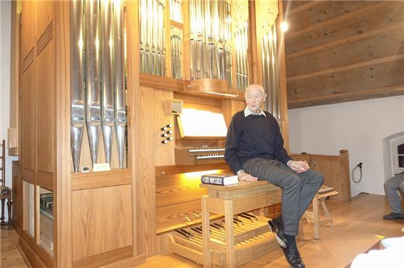 Hans Hofer auf dem Orgelbänkli neben ihm die «Orgelbiebel».