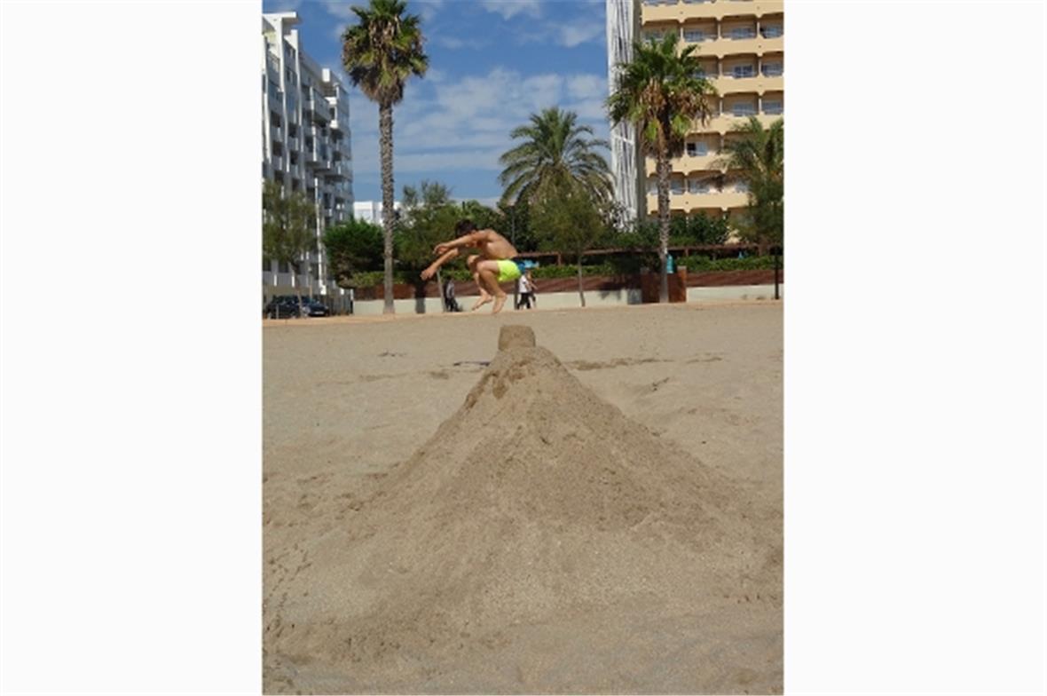 Hüpfen über eigene Sandburg.