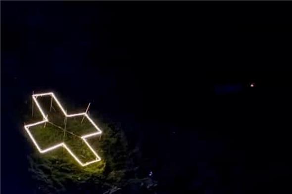 Improvisiert aber erfolgreich: Das LED-Kreuz am Fluesee. Links das Gerüst mit den LED, rechts beleuchtet bei Nacht.