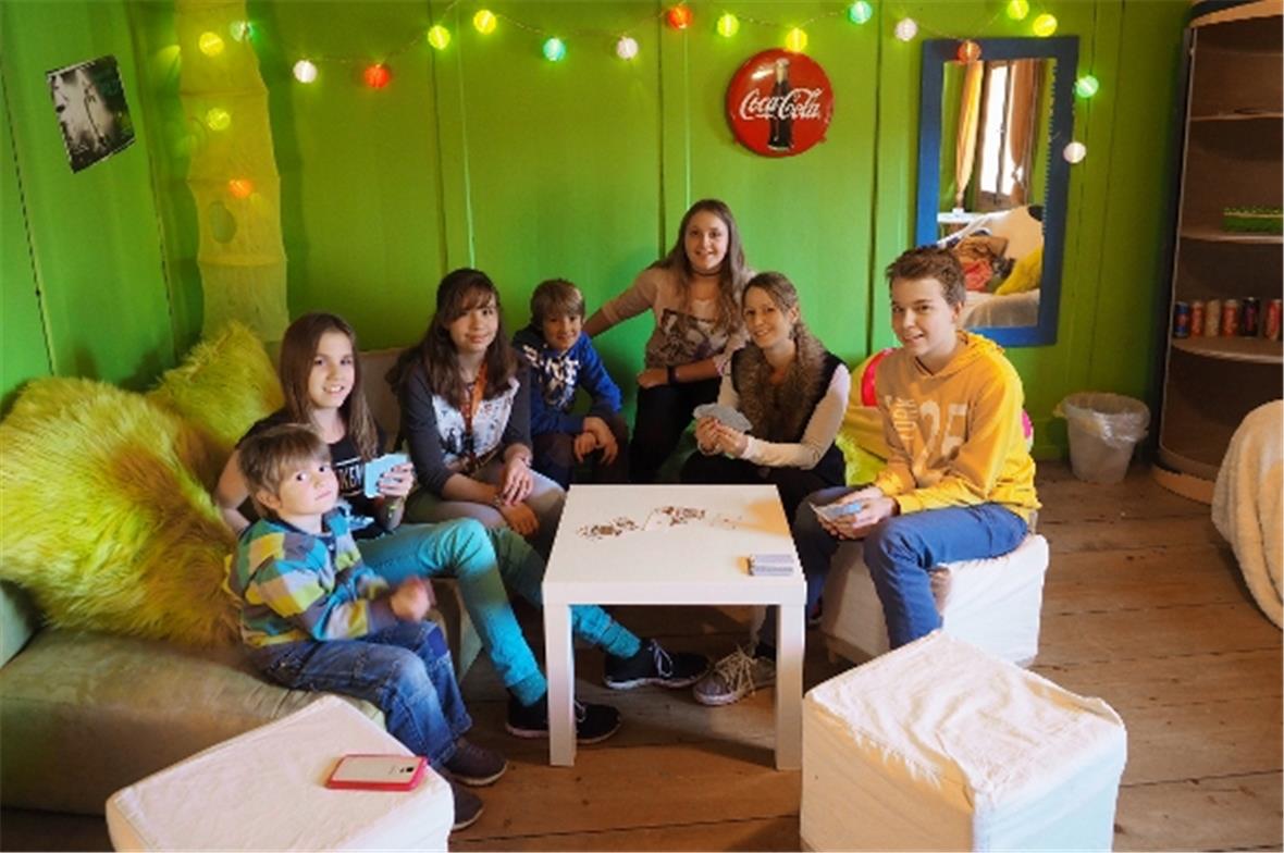 Jugendliche beim «Gemschen» (Kartenspielen) im Meitli-Zimmer, mit Leiterin Lara Pichler.
