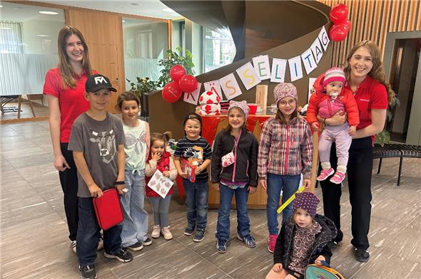 Lernende der Raiffeisenbank Obersimmental-Saanenland mit Kindern, die am Kässelitag ihr Erspartes einzahlten.