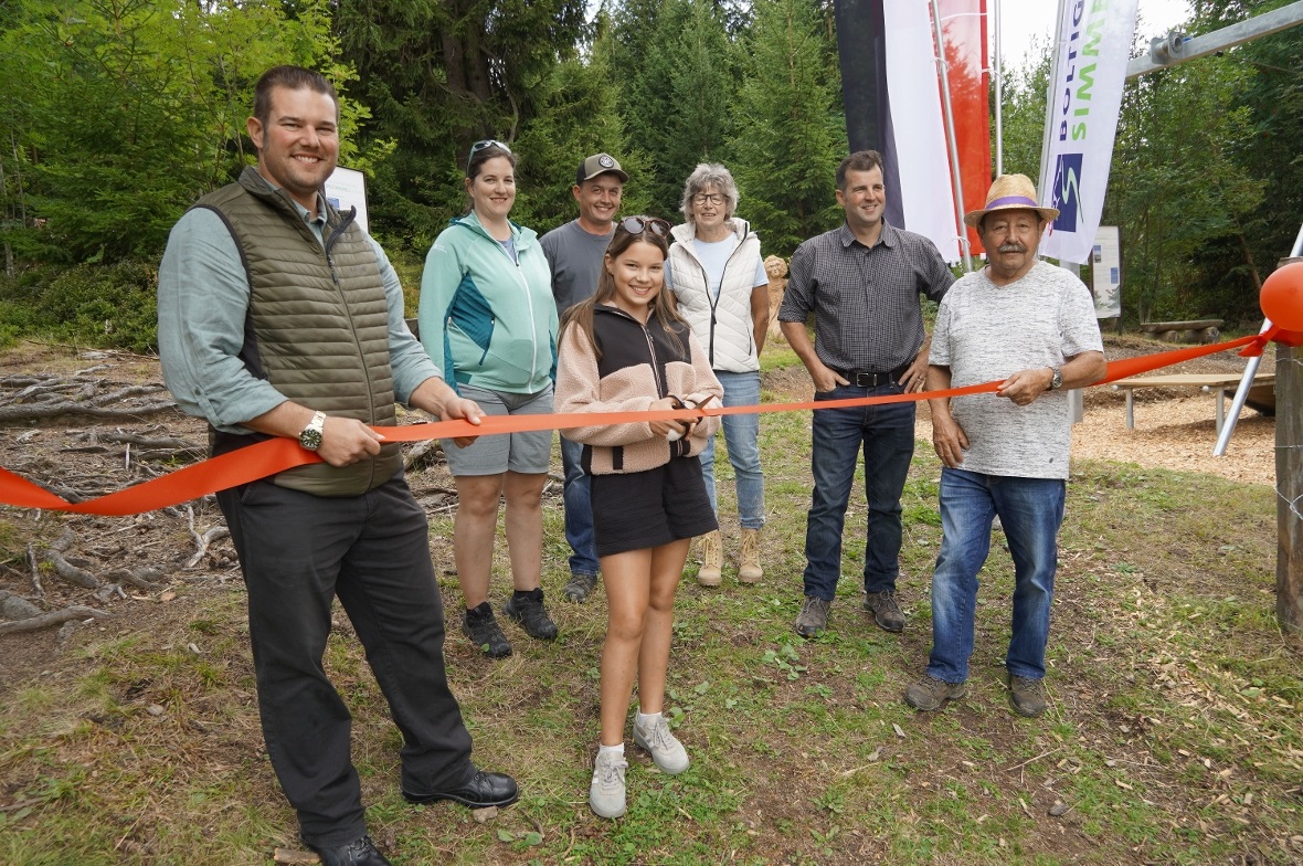 Lisa Poschung zerschnitt das rote Band, im Hintergrund Gemeinderatspräsident Alain Poschung, Annika Hofmann von Lenk-Simmental-Tourismus, Michael Rindlisbacher, Anna Bieri (ehemalige Gemeindepräsidentin), Gemeinderat Erhard Schenk und Gemeindepräsident Albert Wampfler.