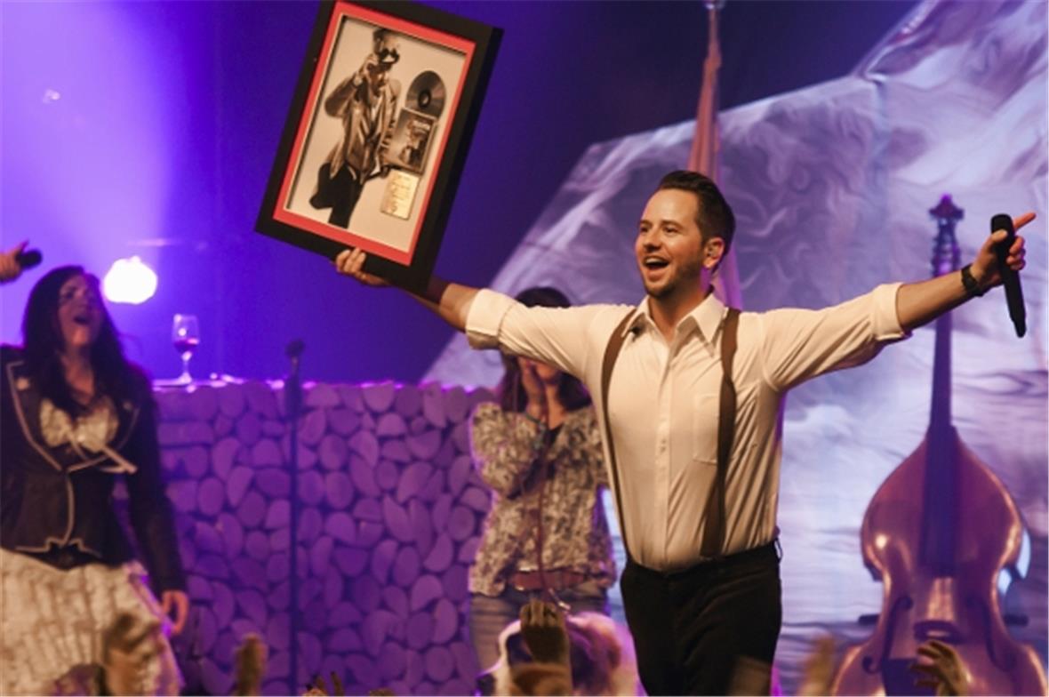 Marc Trauffer bedankt sich bei seinen Fans für die Goldene Schallplatte, links Sängerin Monika Schär.